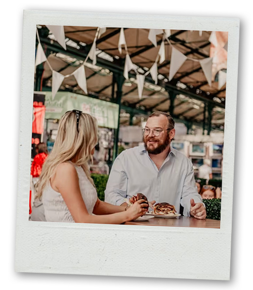 A Polaroid of a man and a woman enjoying some food at St George's Market