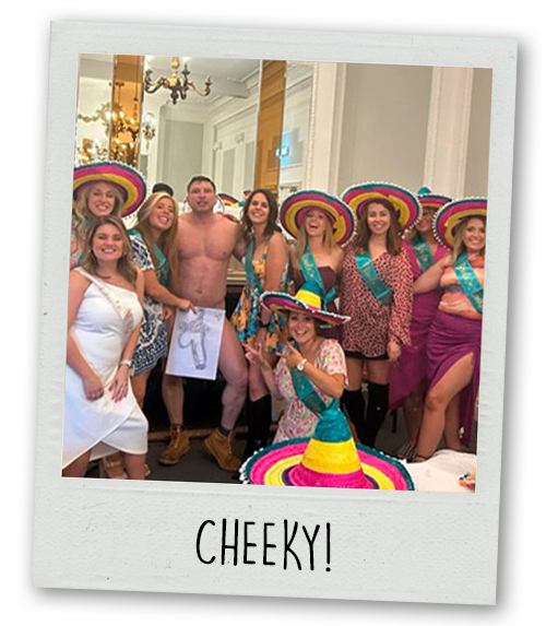 A Polaroid of a hen do group posing with a nude man with the caption Cheeky!