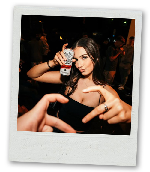 A Polaroid of a woman and someone off camera making a love heart together with their fingers