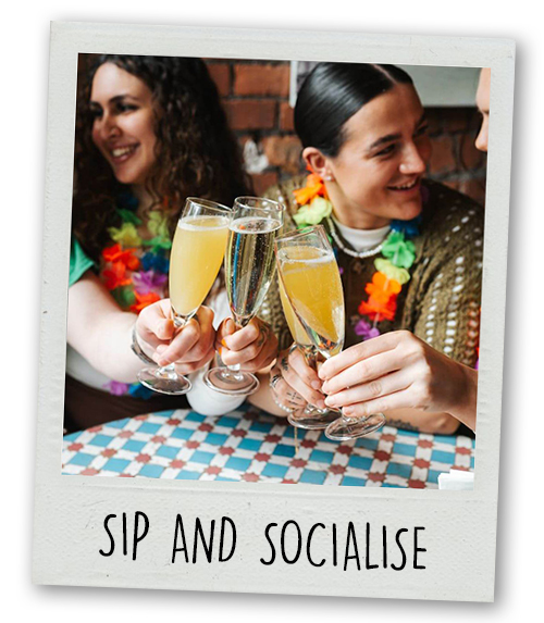 A Polaroid of three women clinking glasses in Revolucion de Cuba with the caption Sip and Socialise