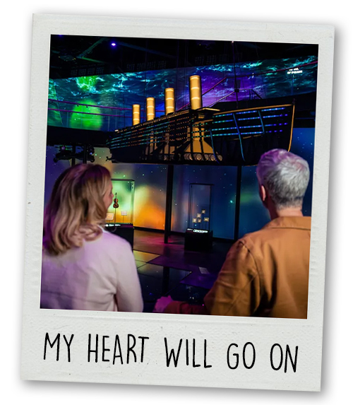 A Polaroid of a man and a woman at one of the Titanic exhibits that's captioned My Heart Will Go On