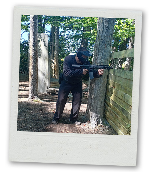 A Polaroid of a man hiding behind a defence with an airsoft gun