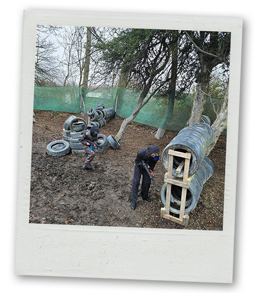 A Polaroid of two men on a stag do hiding behind their defences with their guns