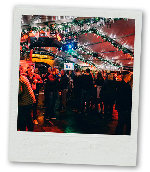 A Polaroid of a group of party goers inside the bar The Three Sisters