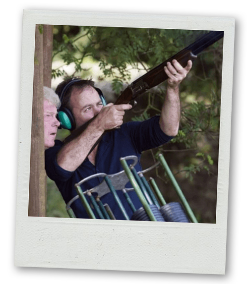 A Polaroid of a guy aiming a clay pigeon shooting gun