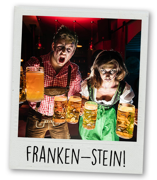 A Polaroid of a man and a woman in a zombie outfit holding steins of beer with the caption Franken-Stein