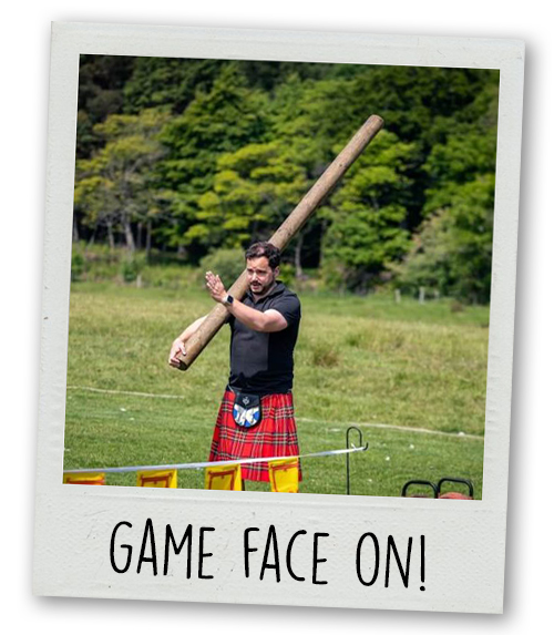 A Polaroid of a man holding a massive caber with the caption Game Face On