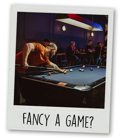 A Polaroid of a man playing pool with the caption Fancy A Game? 
