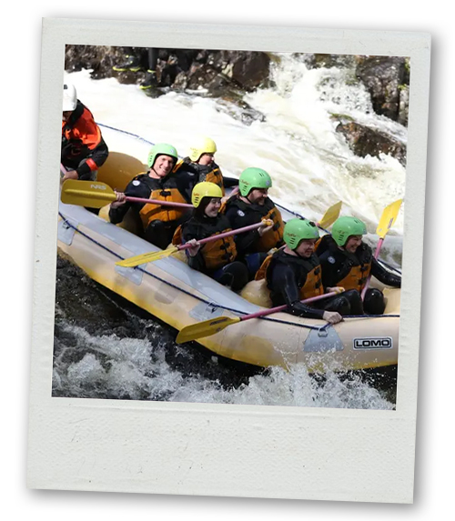 A Polaroid of group of men doing white water rafting and going down a small drop