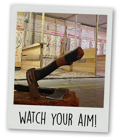 A Polaroid of an axe stuck in the group with the caption Watch Your Aim