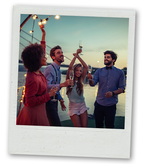 A Polaroid of a mixed gender group raising a toast on a boat