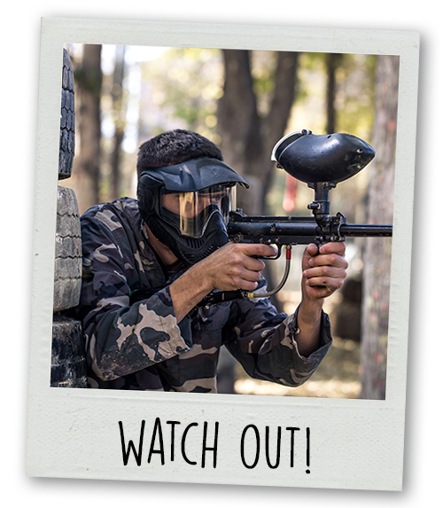 A Polaroid of a man paintballing with the caption Watch Out