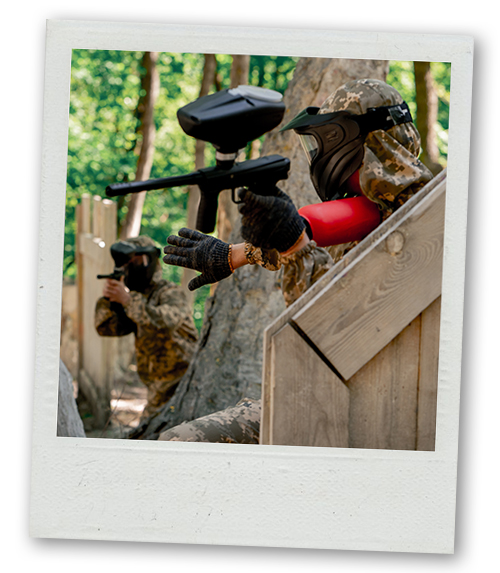 A Polaroid of two men working together on a paintballing team