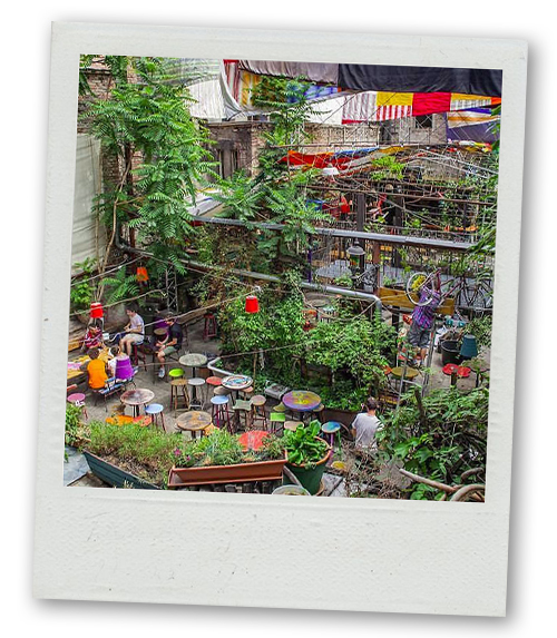 A Polaroid of a garden area of a ruin bar with quirky mismatched furniture