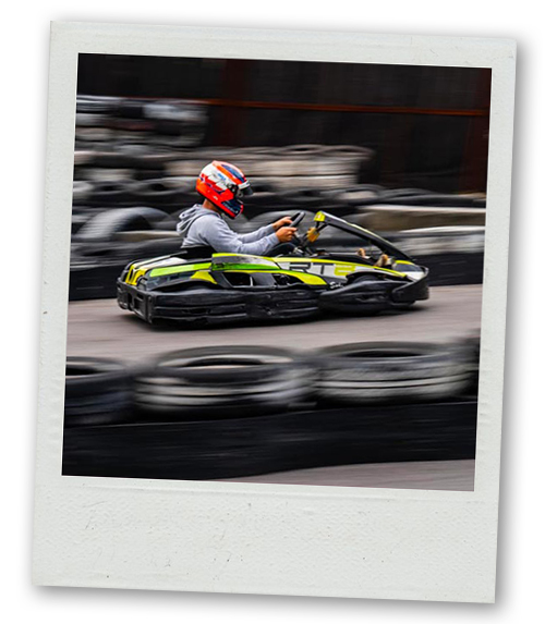 A Polaroid of a man speeding by in a go kart in a blur