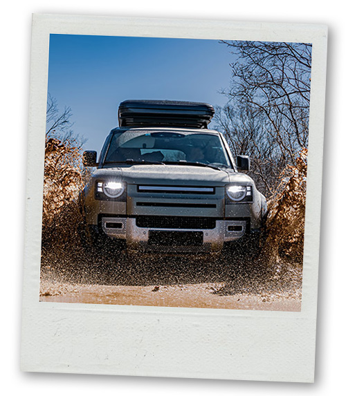 A Polaroid of an off road vehicle driving through the mud