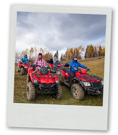 A Polaroid of several people in quad bikes driving down a hill