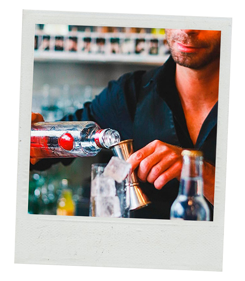 A Polaroid of a male bartender pouring out some vodka