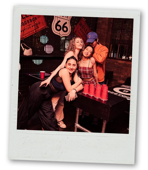 A Polaroid of a group of people playing beer pong