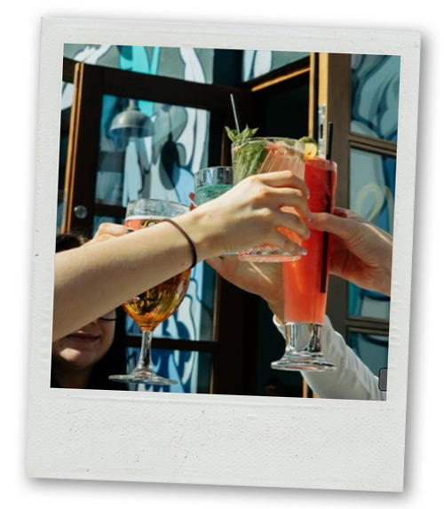 A Polaroid of a group of people clinking cocktails
