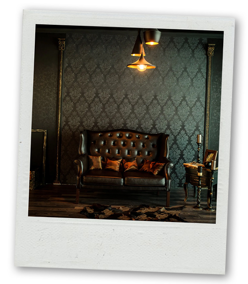 A Polaroid of luxurious room with a leather looking black sofa and atmospheric lighting