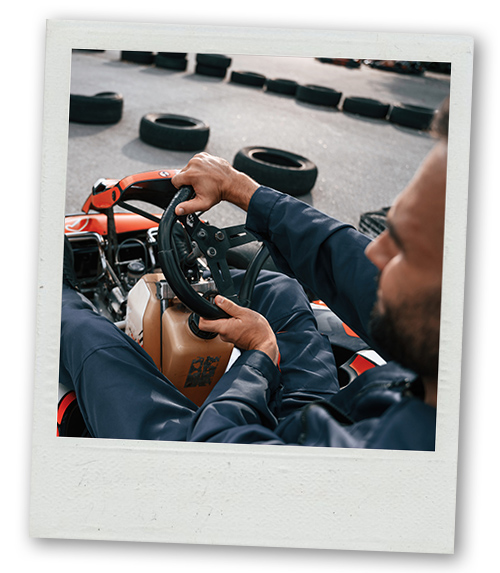A Polaroid of a man behind the wheel of a go kart