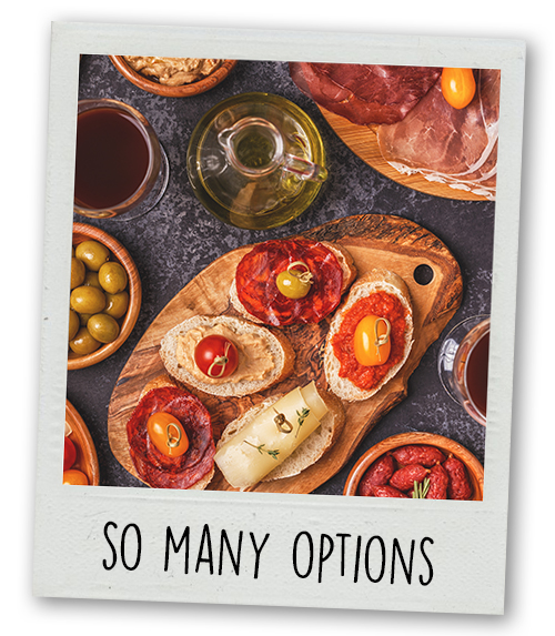 A Polaroid of a selection of tapas with the caption so many options