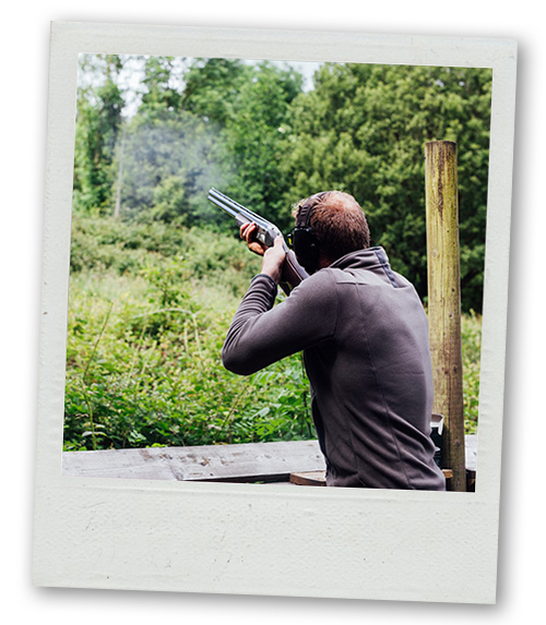A Polaroid of a man shooting a gun in an outdoor shooting range