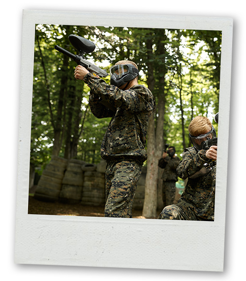 A Polaroid of a group of men paintballing outdoors
