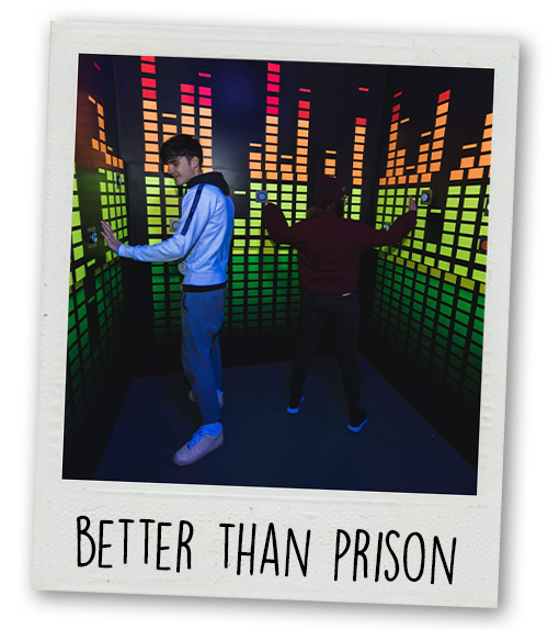 A Polaroid of two people playing a game at Prison Island with the caption Better Than Prison
