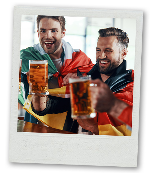 A Polaroid of two men wrapped in flags drinking pints