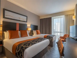 A double bed and single bed in a room at Clayton Hotel Cardiff