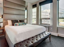 A double bed in a room with a view of the city at Sandman Signature in Newcastle