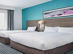 A double bed and a single bed in a teal and white room