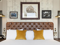 A double bed against a wall with photos above the bed at Hotel Indigo in Edinburgh 