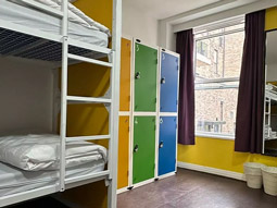 A bunkbed facing a window, with six lockers next to it at Safestay Edinburgh