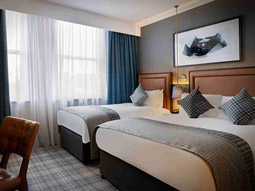A family room with a double bed and a single bed and desk space to work in a room at Leonardo Royal Hotel in Edinburgh