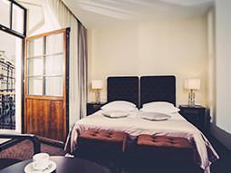 A guest room and open balcony door at the Amberton Hotel