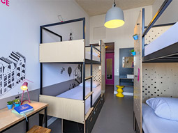 A room with two sets of bunkbeds in and a desk area at Stayokay Hotel in Amsterdam