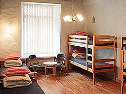 A large room with twin beds, bunk beds and a table and chairs