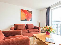 Two red sofas around a coffee table, in an apartment