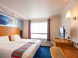 Two double beds facing a wooden desk