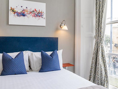 A double room with a piece of artwork above the bed at The Washington Hotel in Bristol