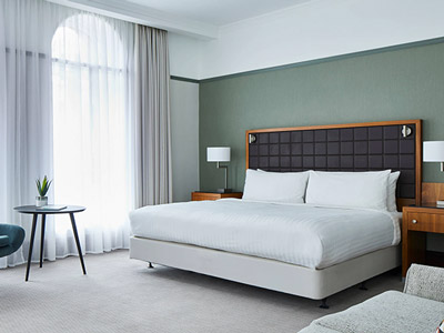 A double bed in a room with large arched windows at Marriott Hotel Leeds 