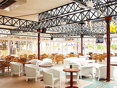 White chairs and tables under a large canopy