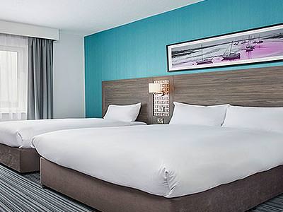 A double bed and a single bed in a teal and white room