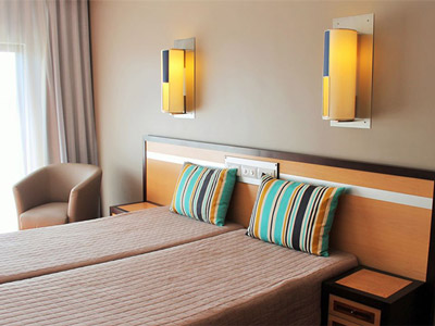 A room with a bed, overhead lighting and a seated area at Paraiso Albufeira Hotel