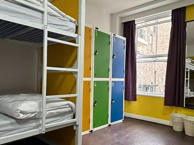 A bunkbed facing a window, with six lockers next to it at Safestay Edinburgh