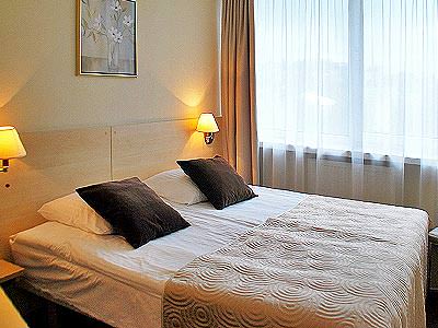 A double bed in a room with brown and cream bedding