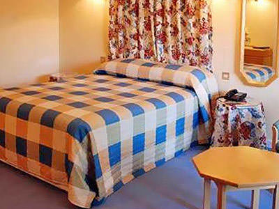 A bedroom with a hexagonal wooden table and a double bed